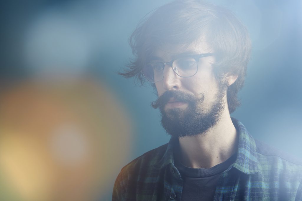 joven con barba, bigote y lentes