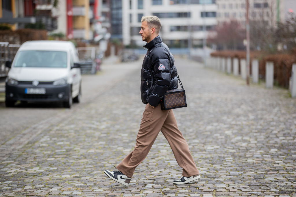 Hombre joven caminando en la calle con tenis Jordan
