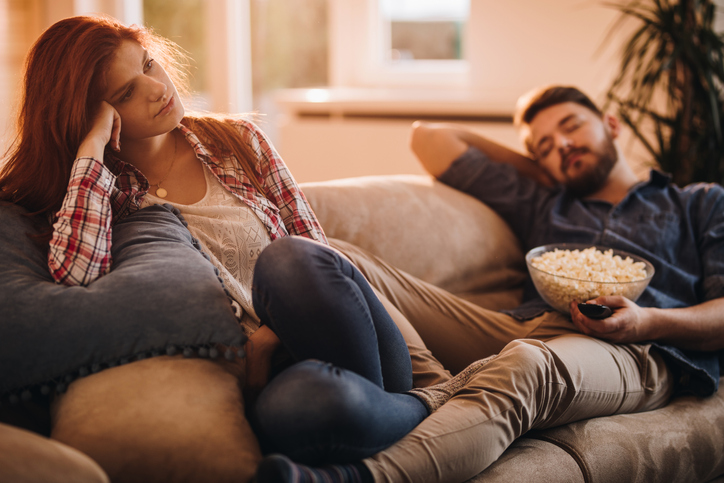 pareja aburrida viendo televisión en casa